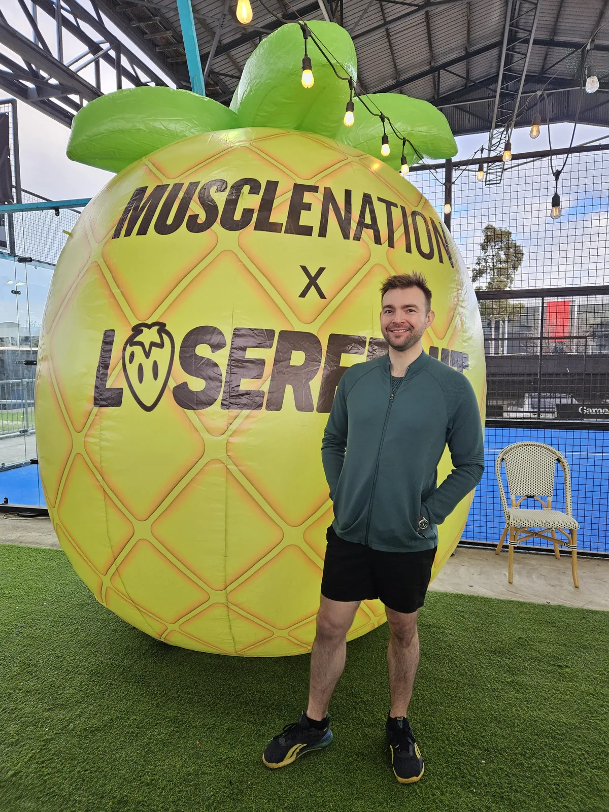 Seb standing beside a large event football installation.