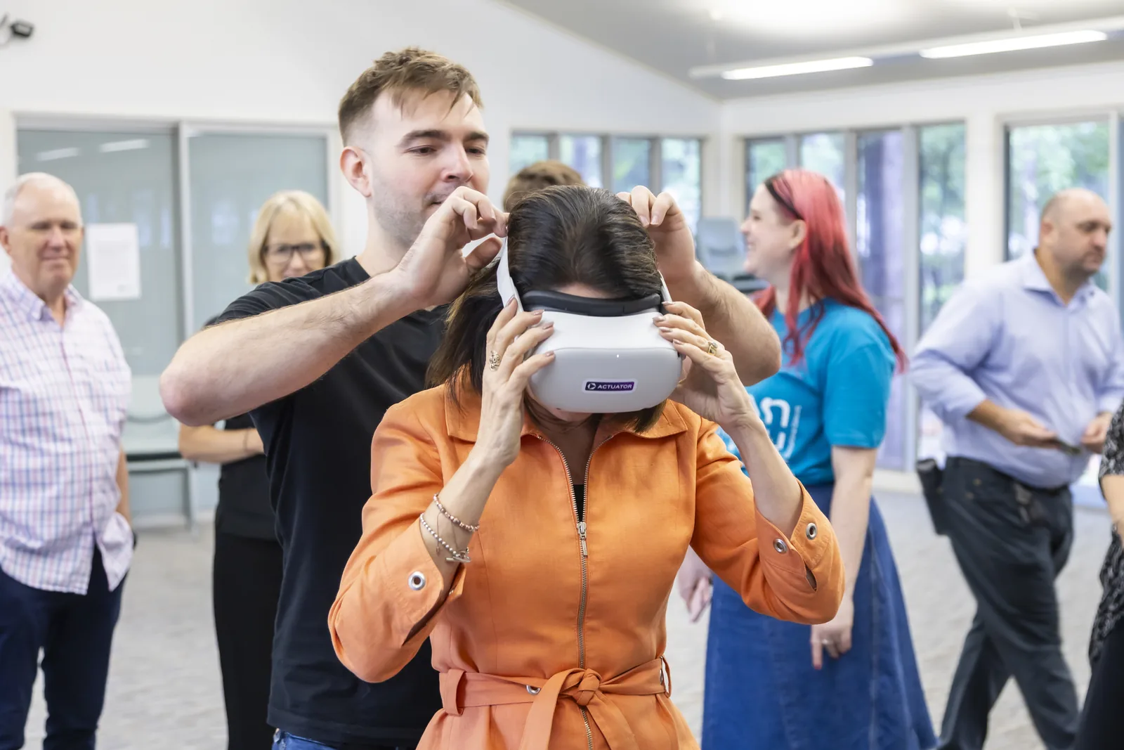 Seb helping an attendee put on a virtual reality headset.