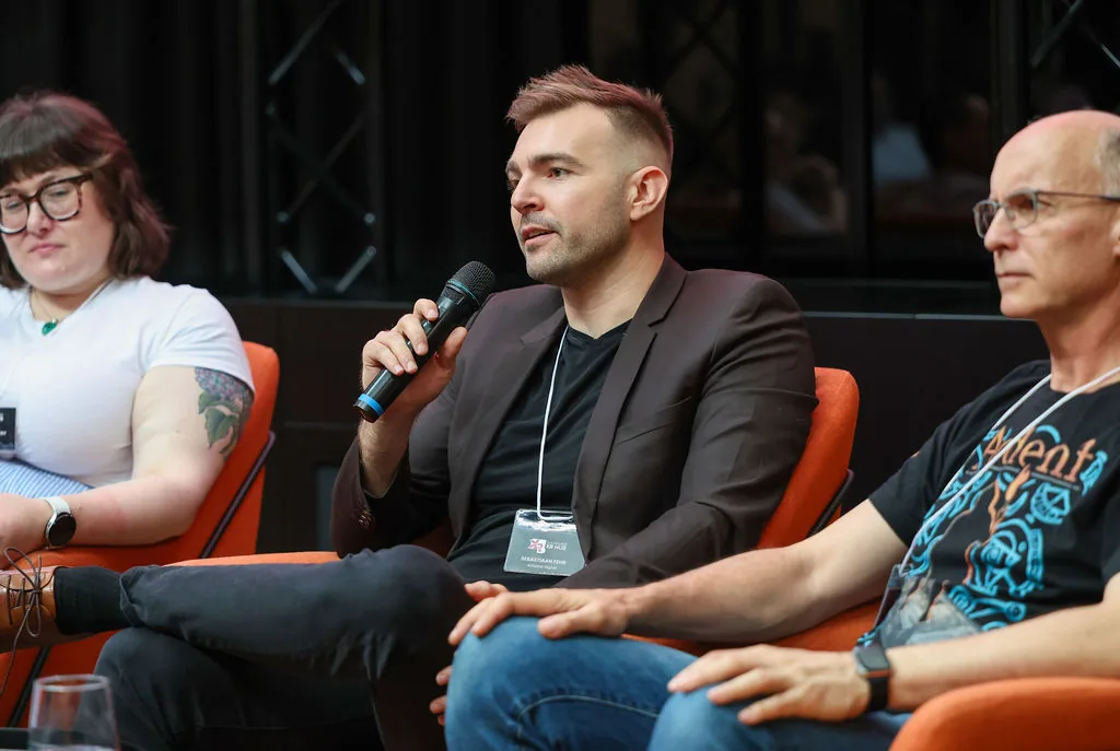 Seb speaking into a microphone during an XR Hub panel.