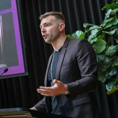 Seb speaking at XR Hub in front of a purple screen.